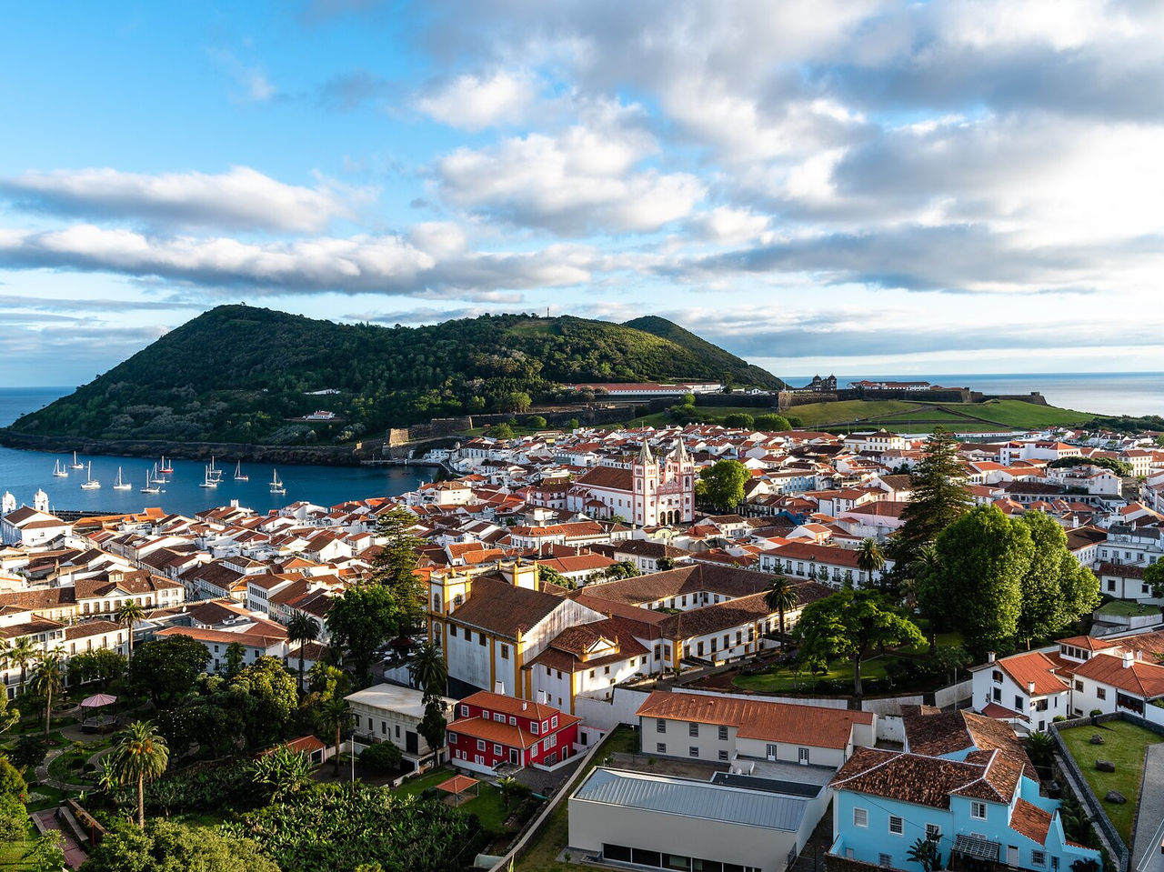 Panoramic view of Angra do Heroísmo, on Terceira Island, surrounded by green hills and the Atlantic Ocean