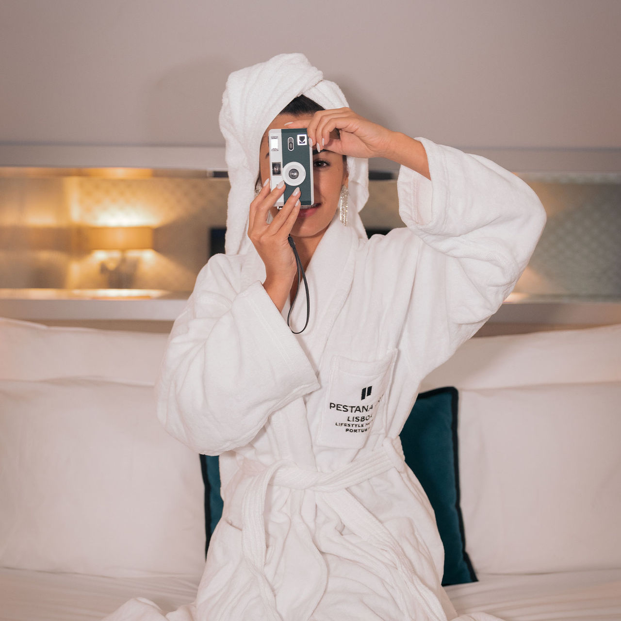 Girl taking a picture with a digital camera in a room at Pestana CR7 Lisboa