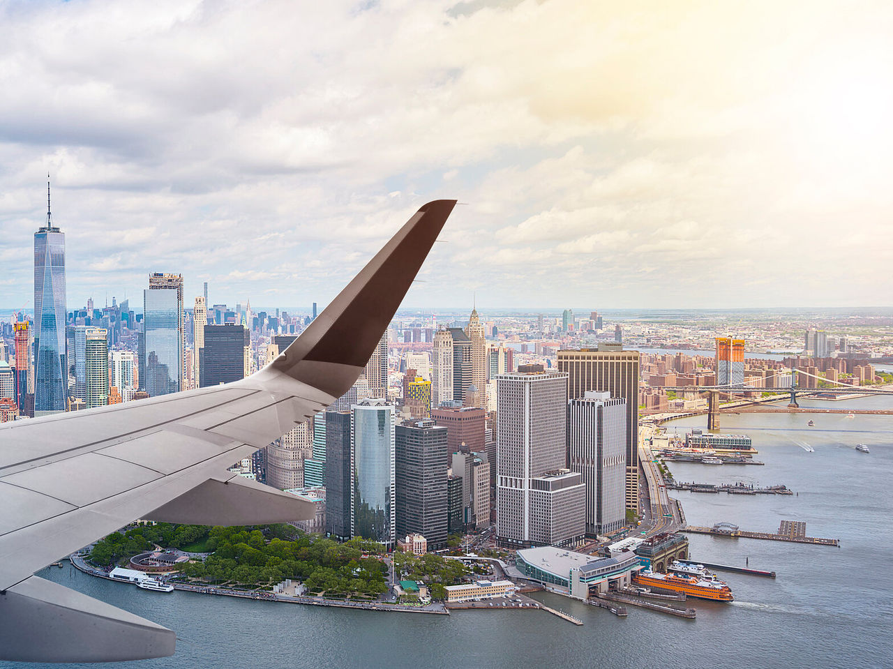 Panoramic view of New York from an airplane window, with iconic skyscrapers and the Hudson River
