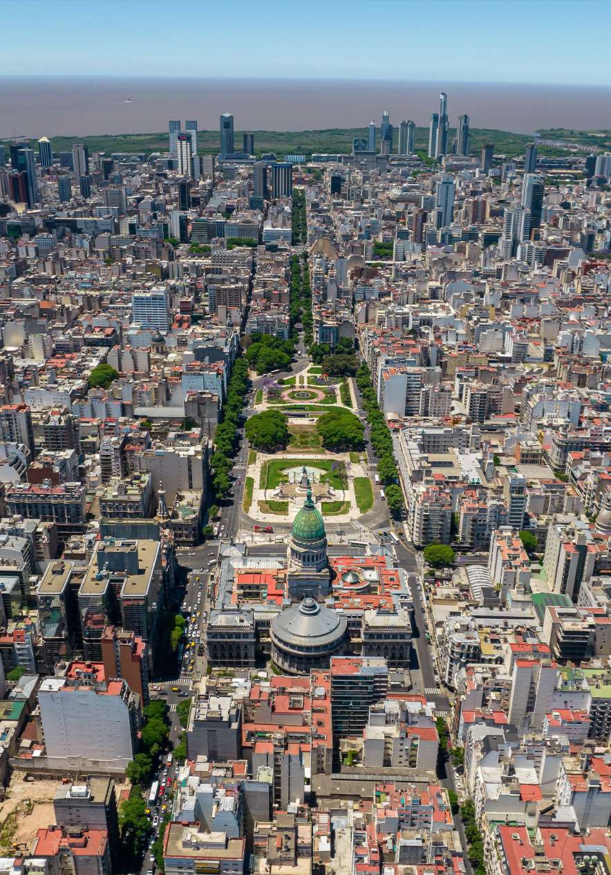 Panoramic view of Puerto Madero in Buenos Aires with modern skyscrapers and calm river waters surrounded by green areas